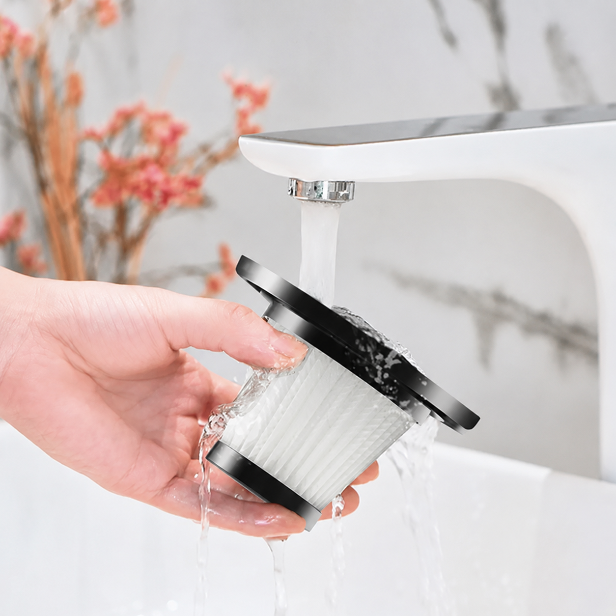 Removable vacuum filter being rinsed under a tap